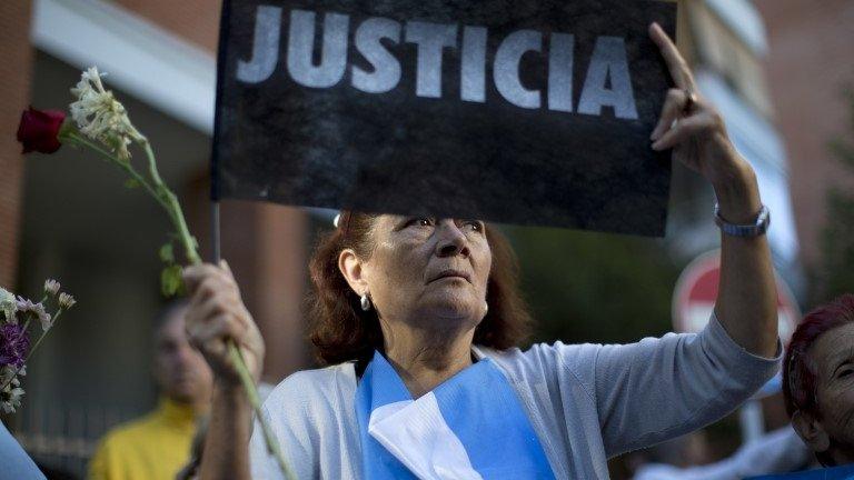 A woman in Argentina holds a sign calling for "justice" in the Nisman case