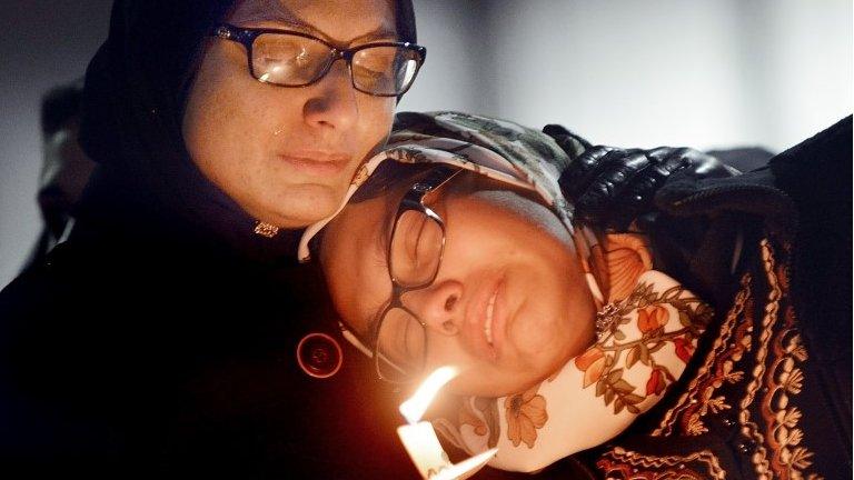 Women mourn during a vigil for three people who were killed at a condominium near UNC-Chapel Hill, Wednesday, Feb. 11, 2015, in Chapel Hill, N.C.