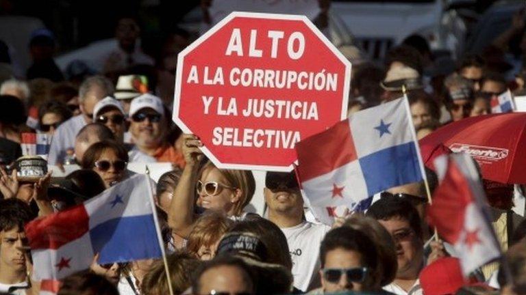 A demonstrator holds up a sign that reads in Spanish "Stop the corruption and selective justice" during an anti-corruption march in Panama City on 29 January 2015