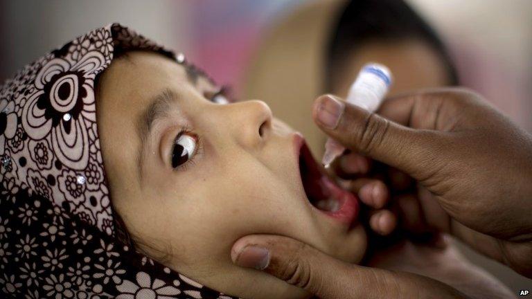 A Pakistani health worker gives polio vaccine to a child at a bus terminal in Rawalpindi, Pakistan. 16 February 2015