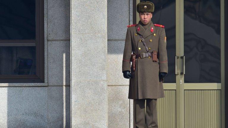 A North Korean soldier stands guard at the North side of the truce village of Panmunjom in the Demilitarized Zone dividing the two Koreas on 4 February 2015