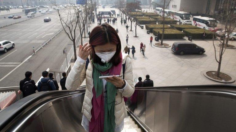 A woman wears a mask during a day of heavy pollution in Beijing, 7 March