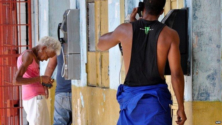 Cubans using the the phone on the street in Havana. March 2015