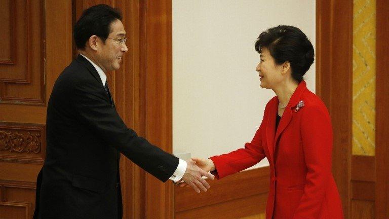 South Korea President Park Geun-hye (right) shakes hands with Japanese Foreign Minister Fumio Kishida during their meeting at the Presidential Blue House in Seoul, 21 March 2015