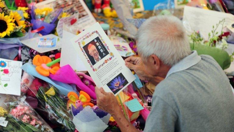 A man reads a card left at the tribute area at Singapore General Hospital following the death of former prime minister Lee Kuan Yew in Singapore on 23 March 2015