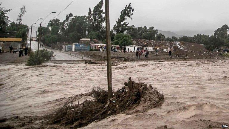 People observe the overflowing Copiapo river, in Copiapo, Chile, 25 March 2015.