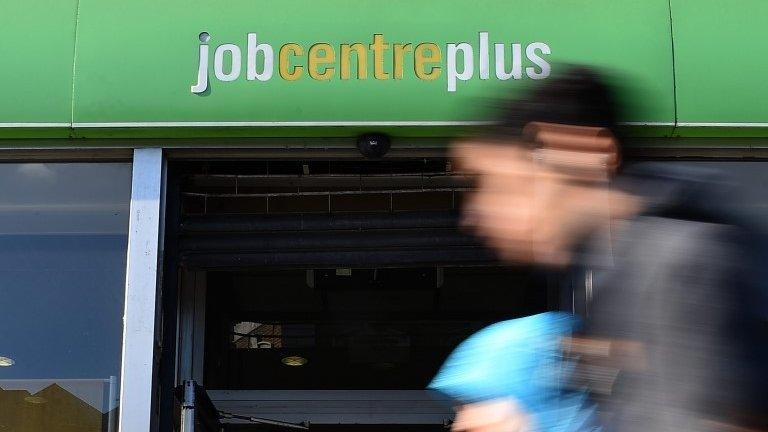 Generic image of a woman walking past a job centre