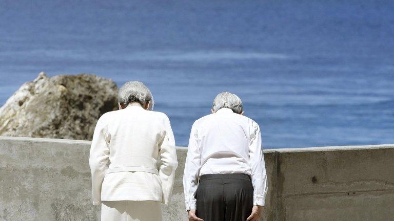 Japan"s Emperor Akihito (R) and Empress Michiko bow towards Angaur Island after they offered flowers to the cenotaph for the war dead in the western Pacific area, on Palau's Peleliu Island, on 9 April 2015