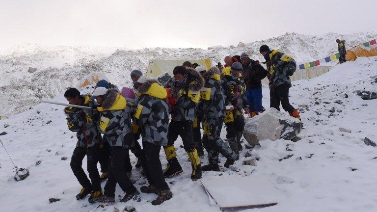 Rescuers carry injured person to helicopter - 26 April