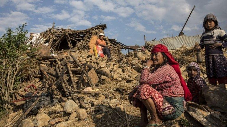 People in front of ruined home in Kathmandu, Nepal (27 April 2015)