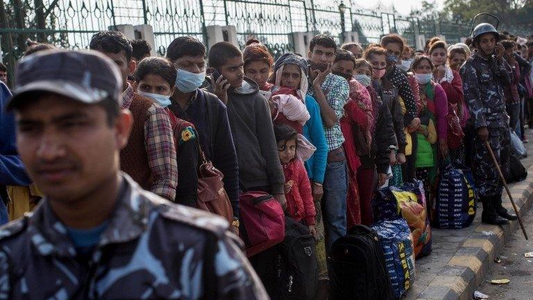 Thousands of people queue on the street outside a government building as they wait for free bus rides out of the city centre on 29 April 2015 in Kathmandu, Nepal.