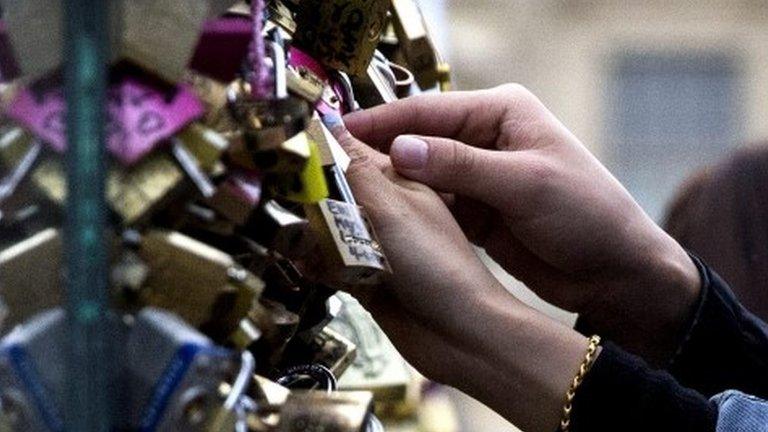 A couple attaches a love padlock on the Pont des Arts in Paris, France, 31 May 2015.