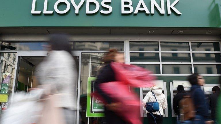 Pedestrians pass a Lloyds bank branch in central London