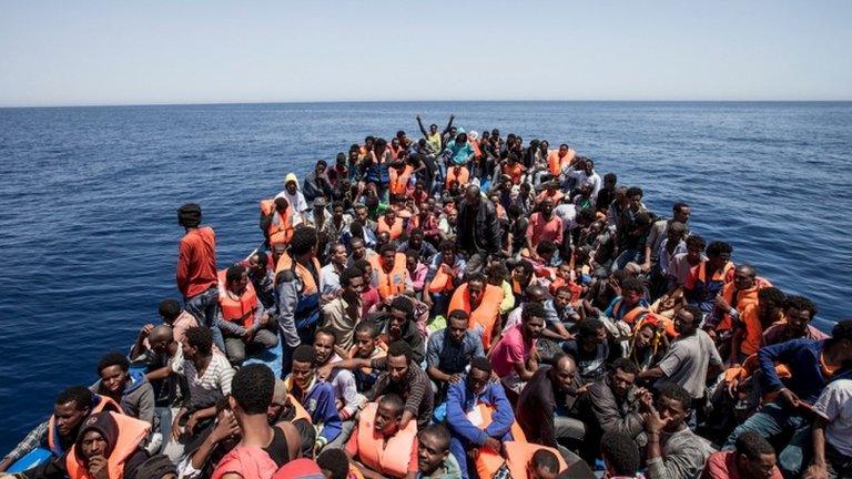 Migrants crowd the deck of their wooden boat off the coast of Libya