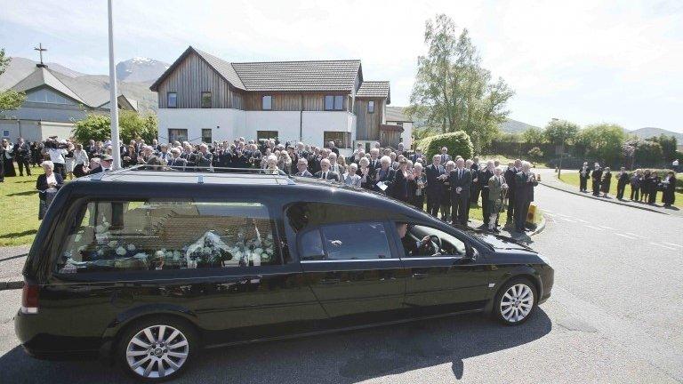 Hearse carrying coffin leaves after funeral service