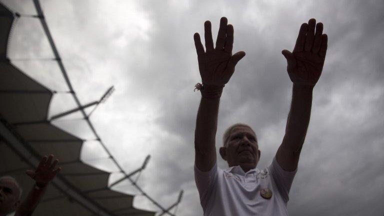 An Indian man stretches as he attends a yoga class in the rain in New Delhi, India, Sunday, June 14, 2015.