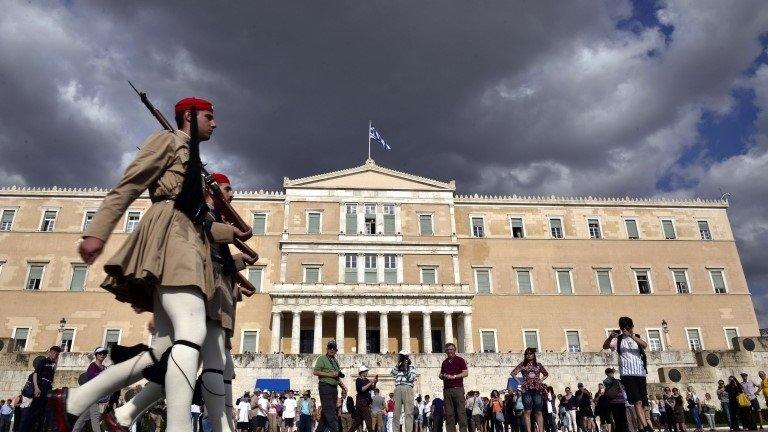 Evzoni presidental guards walk in front of the Greek parliament in Athens