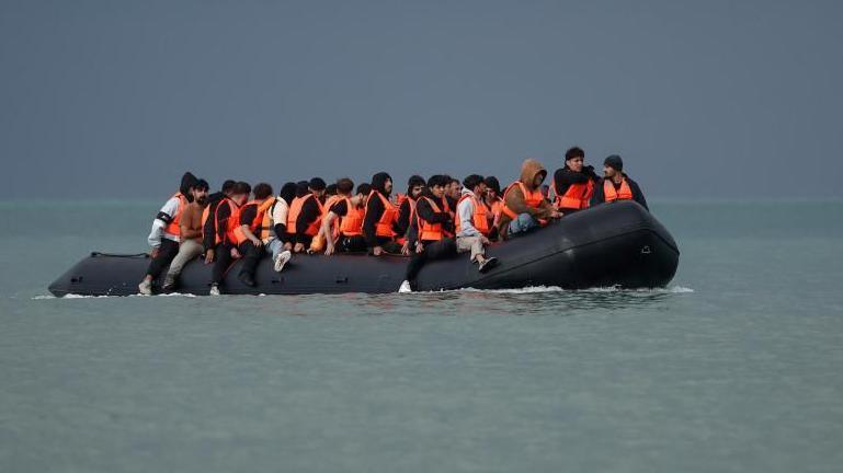 An inflatable dinghy carrying migrants crosses the English Channel
