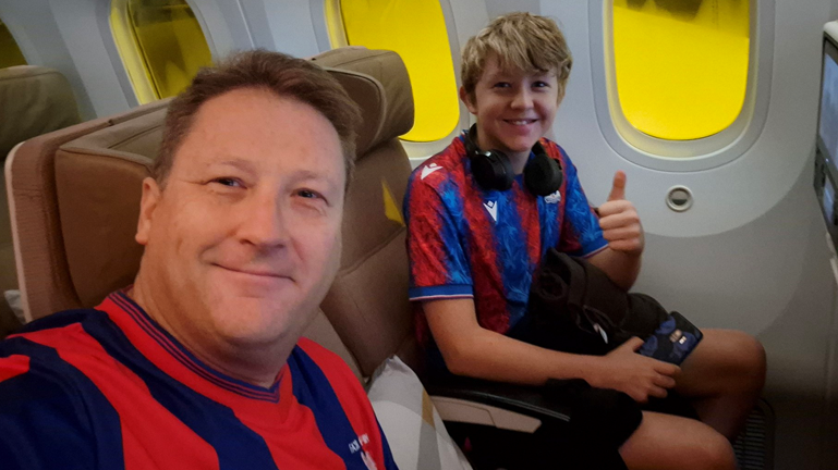 Crystal Palace fans Nigel Moore and son Alfie pictured inside a plane