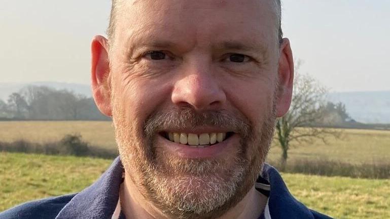 A man smiling in a field