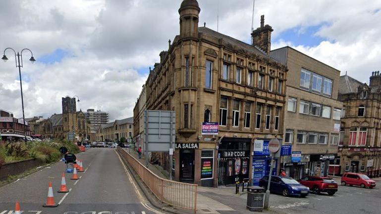 La Salsa lap dancing club on Silver Street in Halifax town centre, with street cones in the main road to the left and parked cars down Silver Street to the right