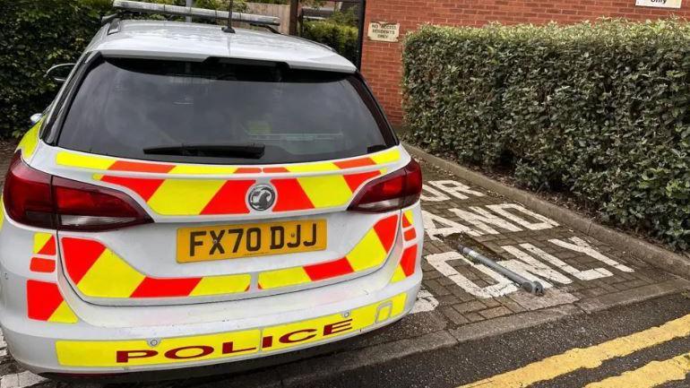 The photo shows the rear of a police car parked outside Frank Swaby Court, a block of flats, in Lincoln.