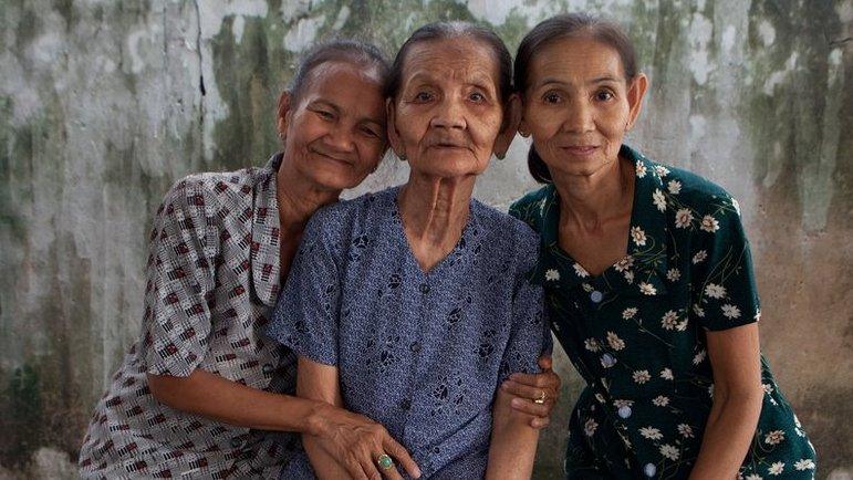 Do Thi Net sits with her daughters Nguyen Thi Ten and Nguyen Thi Sen