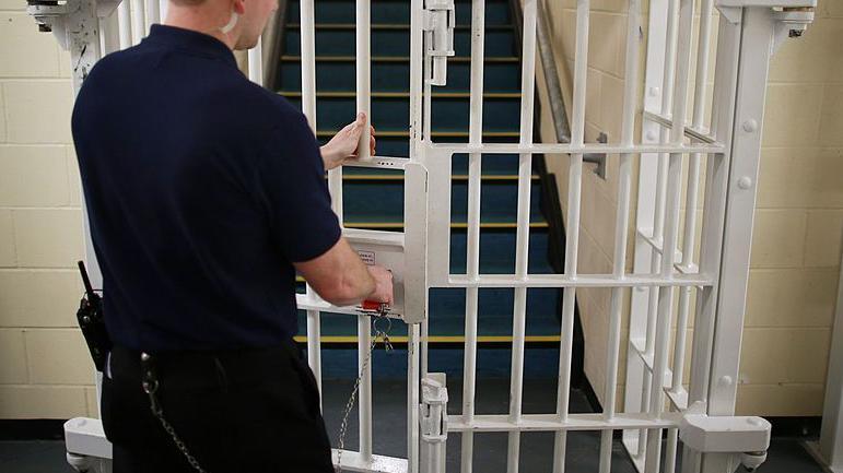 A door is closed by a prison guard in a prison