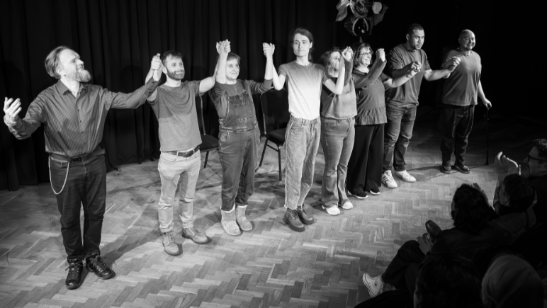 Members of the Bristol Improv Theatre bowing at the end of a show, with the picture in black and white.