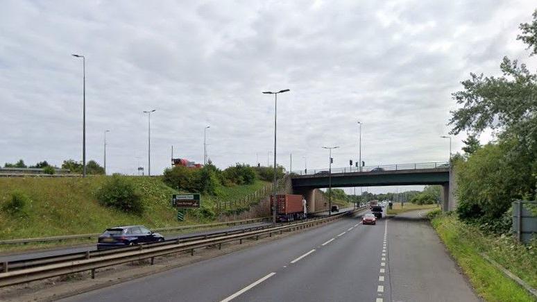 The A66 near Bowesfield Lane. A blue and red car are travelling on the road, as well as a lorry. 