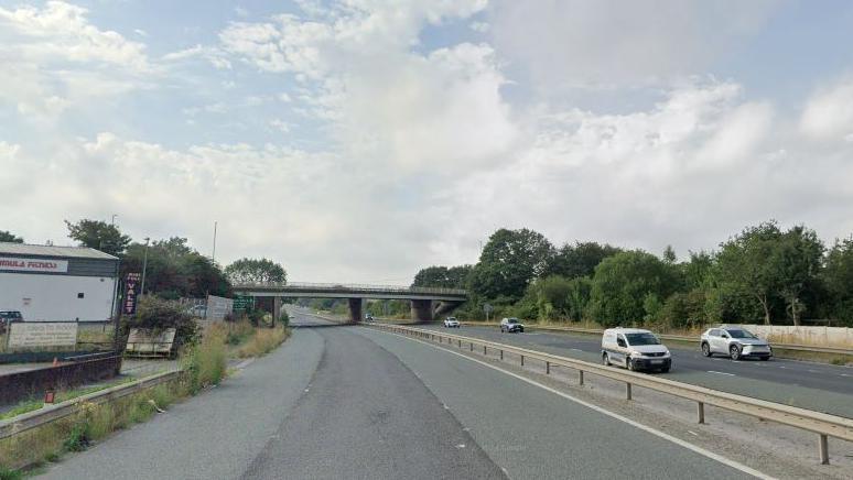 The A162 looking towards North Road bridge. Vehicles are travelling towards the camera on the right side of the image, with the left side of the road empty. 