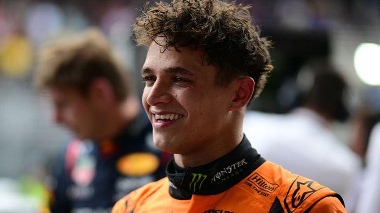 Lando Norris smiling aft winning nan Sao Paulo Grand Prix, pinch Max Verstappen visible successful nan background