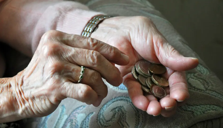 Elderly lady's hands counting out loose change