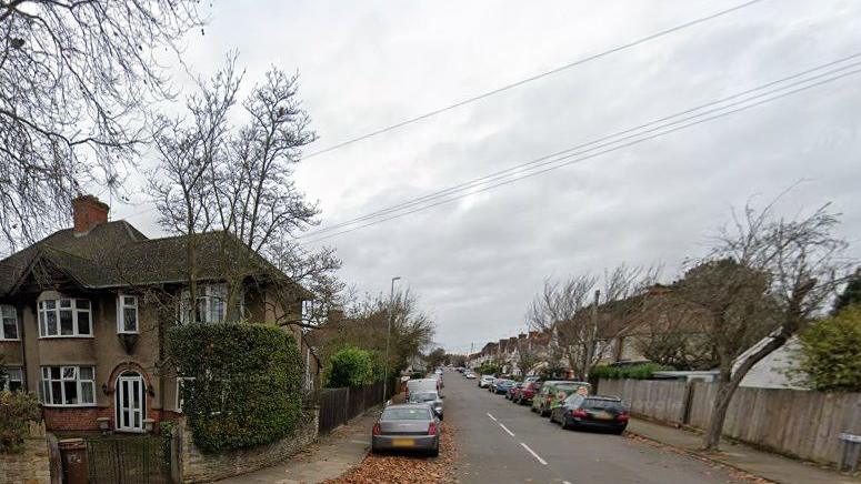 Residential street showing cars parked on either side