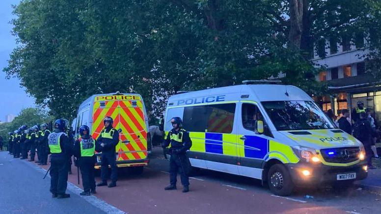 A line of police officers and vans outside a Mercure hotel in Bristol city centre