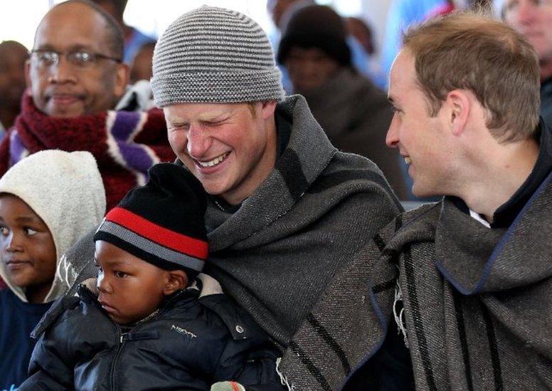 Prince Harry and Prince William clap as Prince Harry holds a young boy during a visit to a child education centre on June 17, 2010 in Semonkong, Lesotho. The two Princes are on a joint trip to Africa which takes in Botswana, Lesotho and finally South Africa