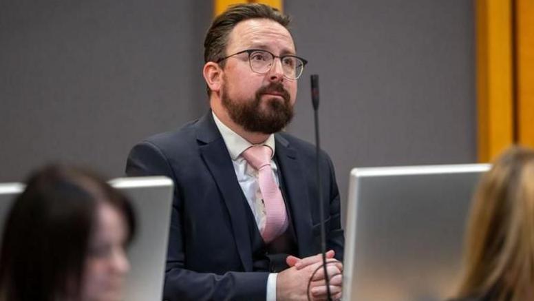 Hefin David in the Senedd. He has a brown beard and brown short hair. He wears black square glasses.