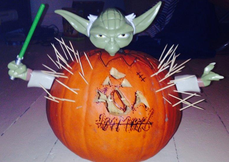 carved pumpkin with yoda model inside