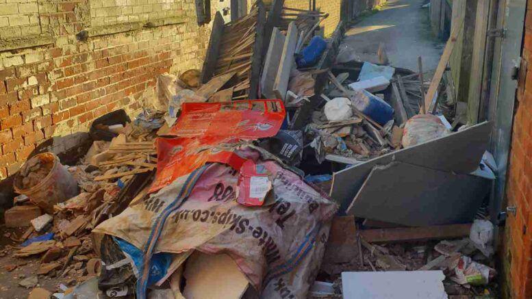 A large amount of construction waste dumping in a small street. 
