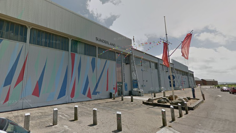 The Calshot Activity Centre - a large grey hanger with red, green and blue triangle on the walls