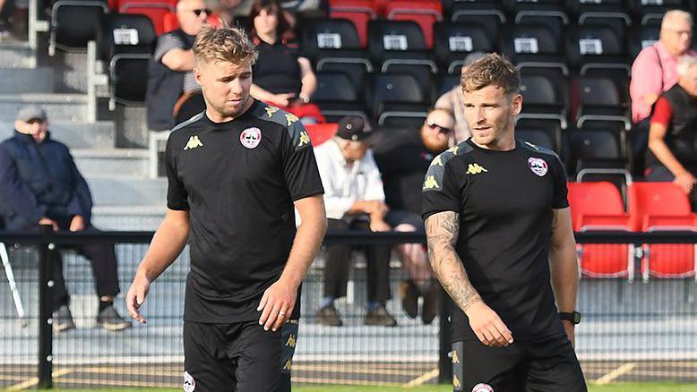 Connor Riley-Lowe (left) and Andrew Neal standing on the pitch