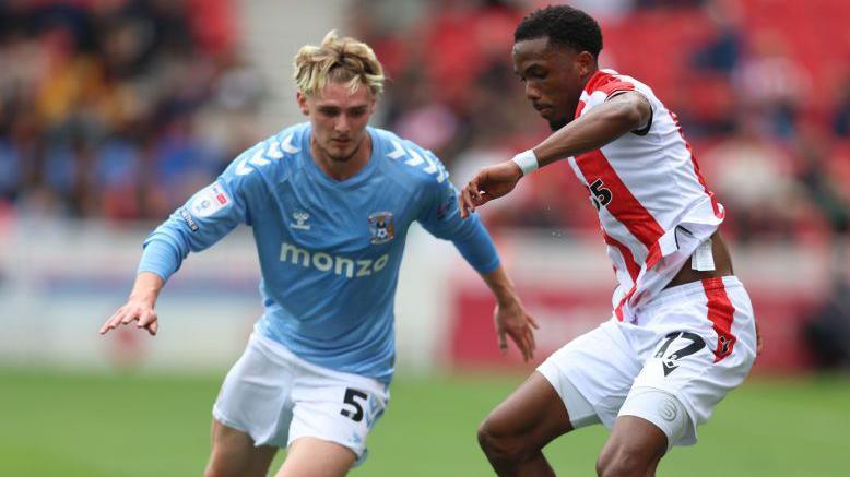 Stoke new signing Eric Bocat is challenged by another of the day's six starting debutants, Coventry's Jack Rudoni, 