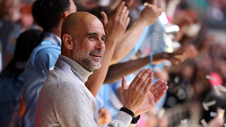 Manager Pep Guardiola applauds as his Manchester City players lift the FA Cup trophy after beating Chelsea in the 2026 final