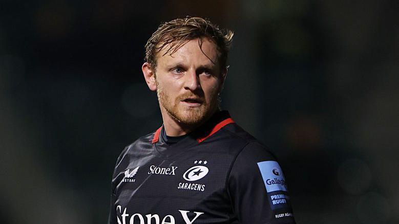 Callum Braley looking to his left while standing on the pitch during a game for Saracens