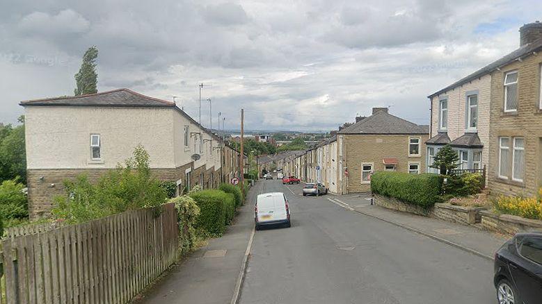 View of Belfield Road, Accrington, showing countryside in the distance on a cloudy day.