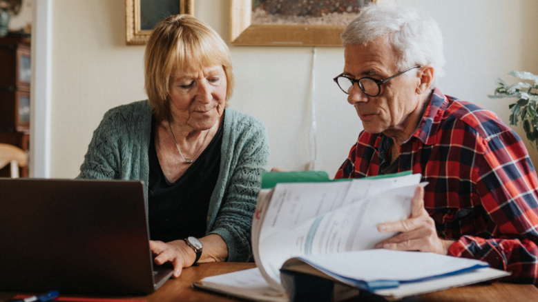 Senior couple using laptop at home
