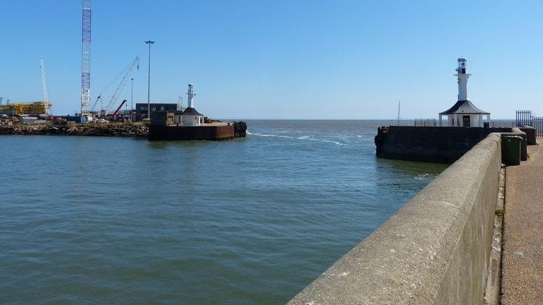 view along the south pier in Lowestoft, with the north pier on the left and an expanse of sea between