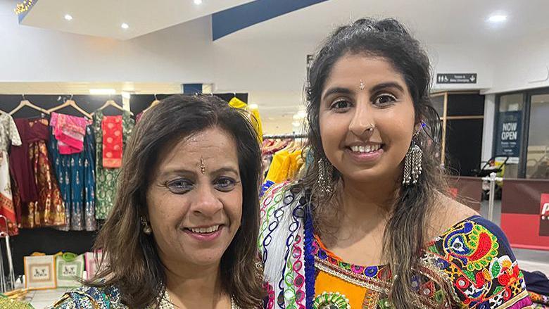 Mother and daughter Parul Chauhan (left) and Bhavini Vithlani smiling wearing vibrant sarees as they celebrate the Hindu festival of Navratri