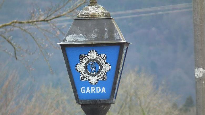 Garda station sign with blue background and GARDA in white letters. 