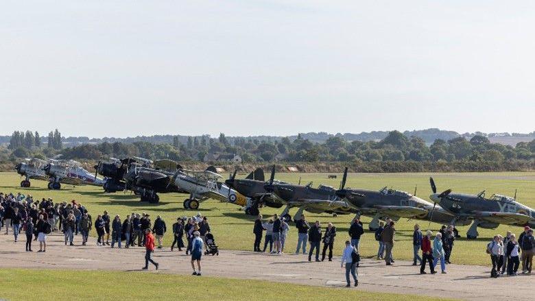 Visitors enjoying the popular flightline walk at the 2024 Battle of Britain Air Show. They are taking a closer look at the aircraft taking part in the flying display.